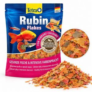 Hrana pesti Tetra Rubin plic 12 gr cu fulgi colorati pentru pesti ornamentali, prezentata alaturi de hrana si detaliu marit al fulgilor.